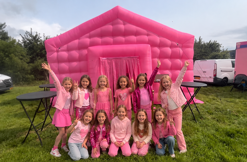 Kinderen bij een roze opblaasbare feesttent